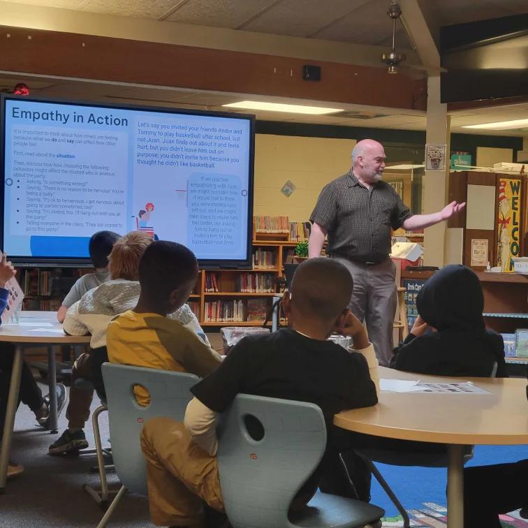 A school counselor teaching a classroom of students about mental health